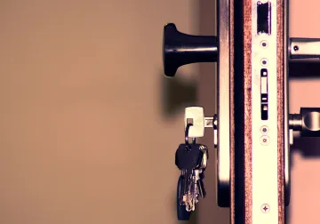 Cerradura y llaves en el canto de una puerta de madera