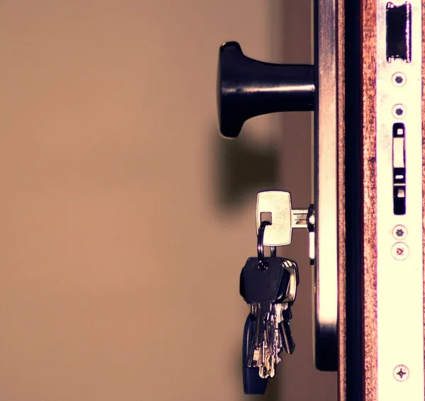 Cerradura y llaves en el canto de una puerta de madera